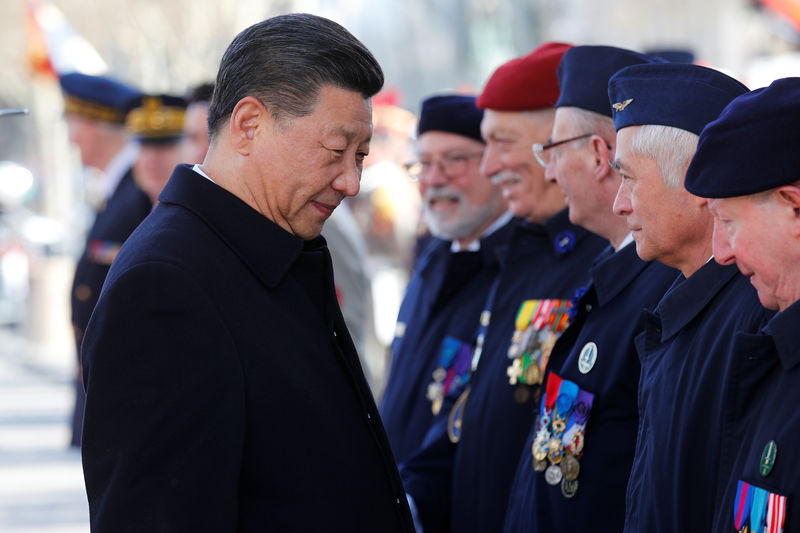 © Reuters. Chinese President Xi Jinping shakes hands with veterans after attending a wreath laying ceremony with his French counterpart, Emmanuel Macron at the Arc de Triomphe monument, in Paris