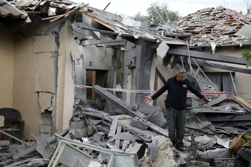 © Reuters. Autoridade policial inspeciona casa que ficou destruída após ser atingida por míssil ao norte de Tel Aviv, em Israel