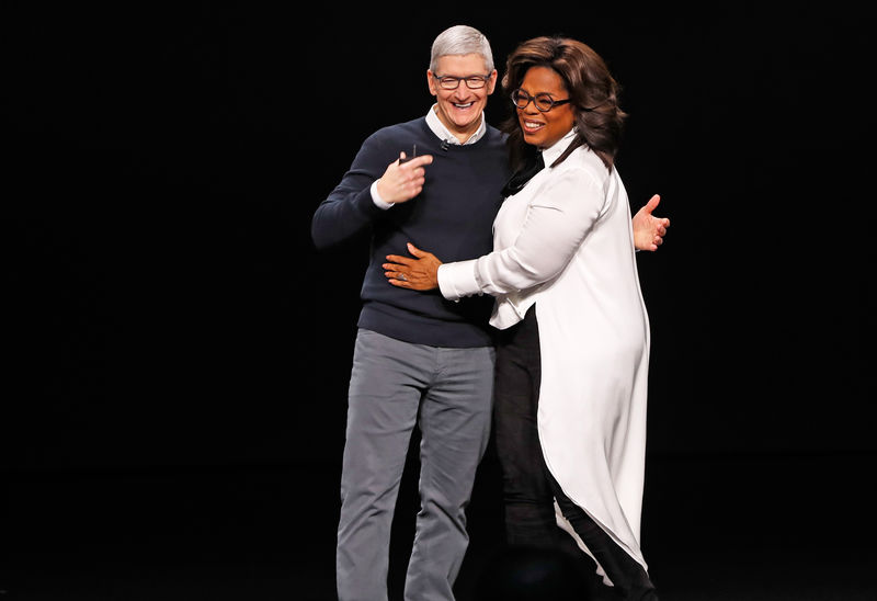 © Reuters. Tim Cook, CEO of Apple and Oprah Winfrey hug during an Apple special event at the Steve Jobs Theater in Cupertino
