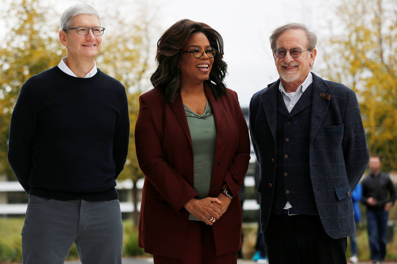 © Reuters. El presidente ejecutivo de Apple, Tim Cook, la presentadora Oprah Winfrey y el director Steven Spielberg posan para una fotografía durante un evento de la compañía en Cupertino, California.