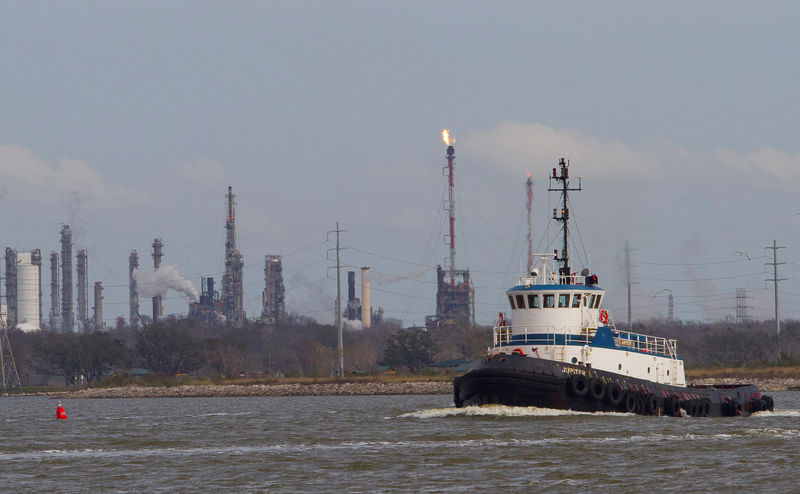 © Reuters. Barco passa pelo canal de Houston, com refinarias ao fundo
