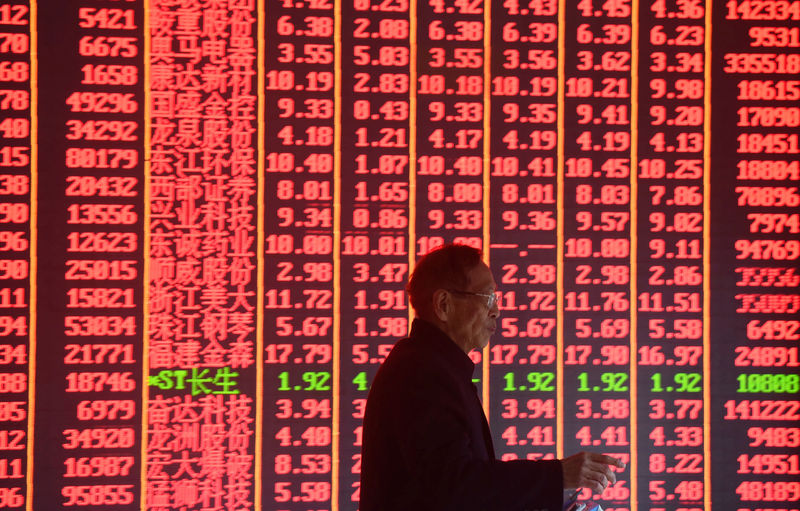 © Reuters. FILE PHOTO: Man is seen in front of an electronic board showing stock information on the first day of trading in the Year of the Pig at a brokerage house in Hangzhou