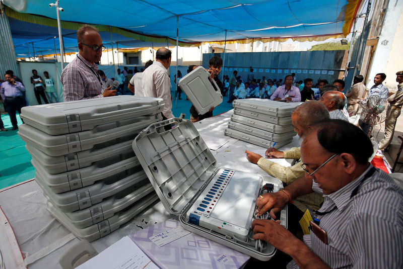 © Reuters. Un miembro del personal electoral verifica una Máquina de Votación Electrónica antes de las elecciones generales de la India en Ahmedabad