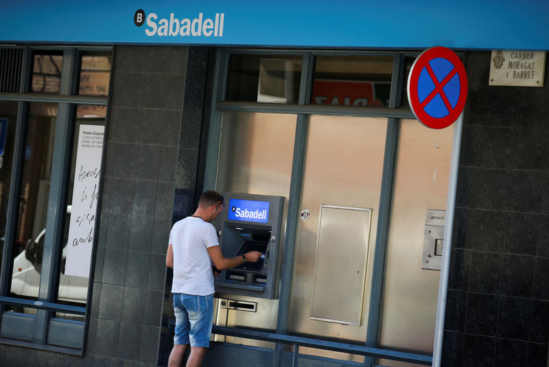 © Reuters. FILE PHOTO: A man uses a cashpoint at a Sabadell bank branch in Pineda de Mar