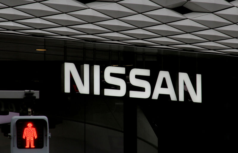 © Reuters. FILE PHOTO : The logo of Nissan Motor Co. is seen at its show room behind a traffic sign in Tokyo