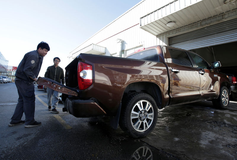 © Reuters. A worker closes the back of a Toyota Tundra pickup truck at Pickup Fan Club, on the outskirts of Beijing