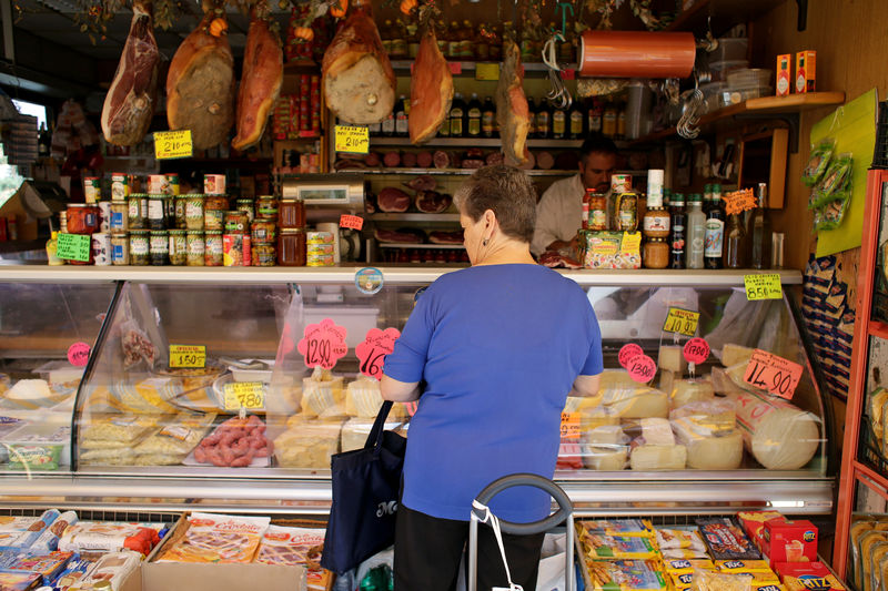 © Reuters. FILE PHOTO: A woman buys cheese in a street market in Rome