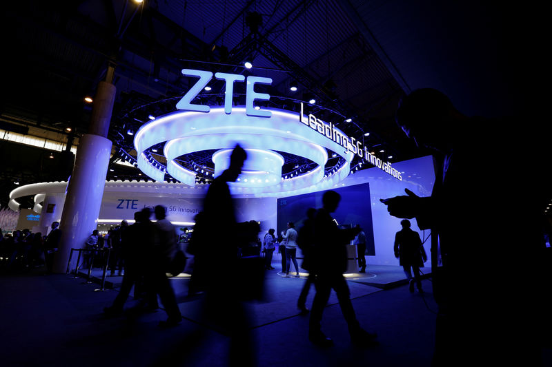 © Reuters. FILE PHOTO: People walk next to ZTE booth at the Mobile World Congress in Barcelona