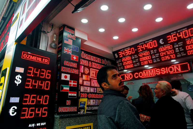 © Reuters. FILE PHOTO: People check currency exchange rates at an currency exchange office in Istanbul