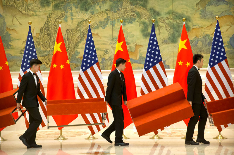 © Reuters. FILE PHOTO: Aides set up platforms before a group photo with members of U.S. and Chinese trade negotiation delegations at the Diaoyutai State Guesthouse in Beijing