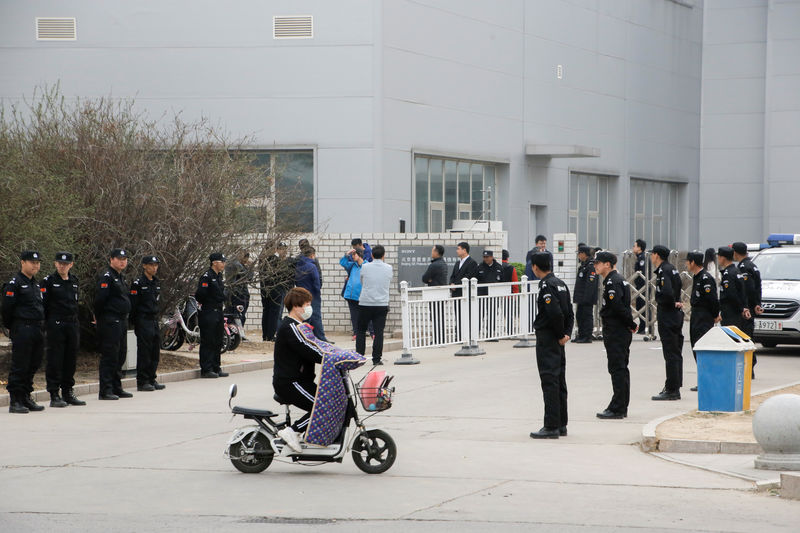 © Reuters. Security personnel stand outside a Sony smartphone plant as workers leave the compound in Beijing
