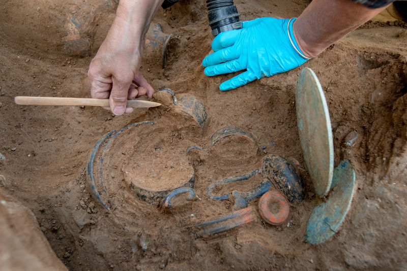 © Reuters. Un arqueólogo trabaja en una tumba etrusca que contiene un esqueleto y docenas de objetos en Aleria, en el este de la isla mediterránea francesa de Córcega