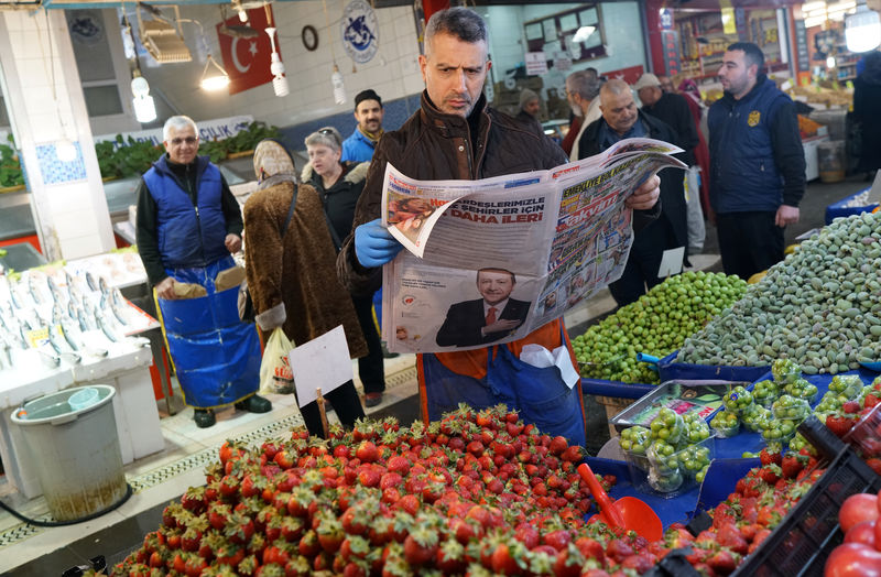 © Reuters. A stallholder reads a newspaper as he waits for customers at a bazaar in Ankara