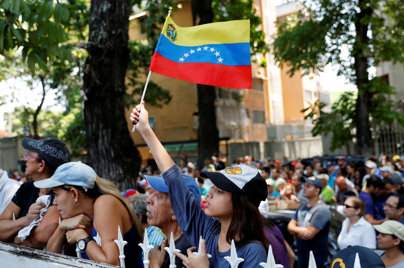 © Reuters. Una mujer ondea una bandera venezolana en Caracas