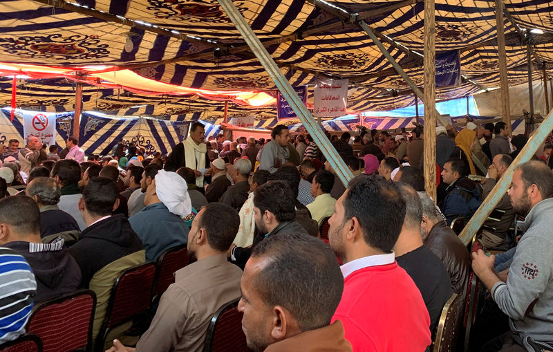 © Reuters. Egyptians sit inside a tent as they wait to submit petitions relating to various concerns over the state's food subsidy programme in a suburb of Cairo