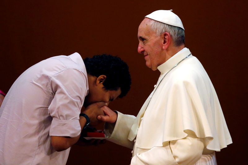 © Reuters. FILE PHOTO: A youth kisses the ring of Pope Francis during a meeting at the municipal theater in Rio de Janeiro