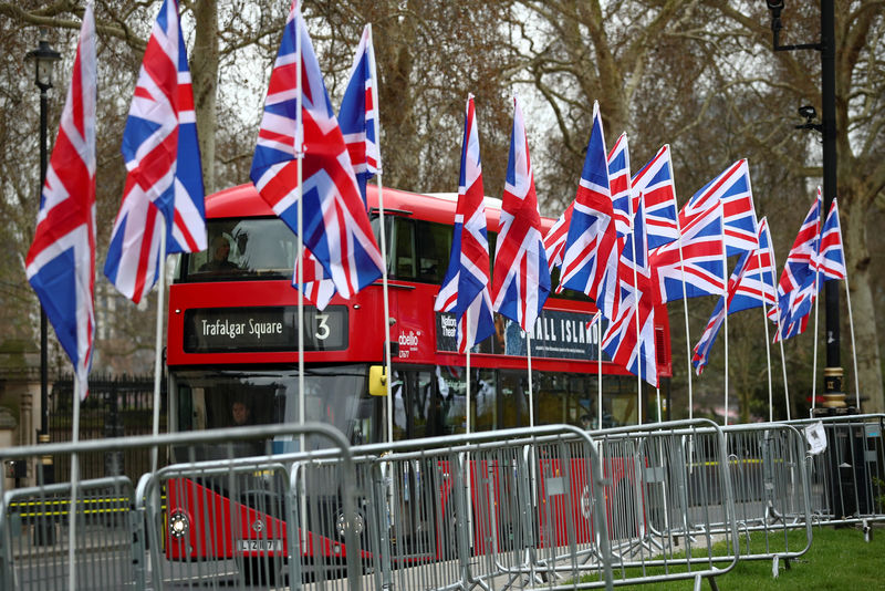 © Reuters. A double-decker bus passes by Union Jack flags displayed by pro-Brexit supporters outside the Houses of Parliament, following the Brexit votes the previous evening, in London