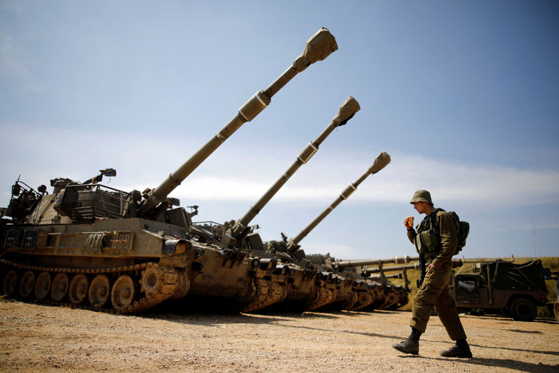 © Reuters. Soldado israelense passa por bateria de canhões perto da fronteira com Gaza, no sul de Israel