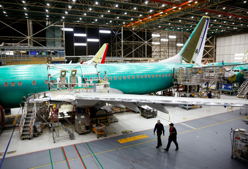 © Reuters. Two workers walk under the wing of a 737 Max aircraft at the Boeing factory in Renton