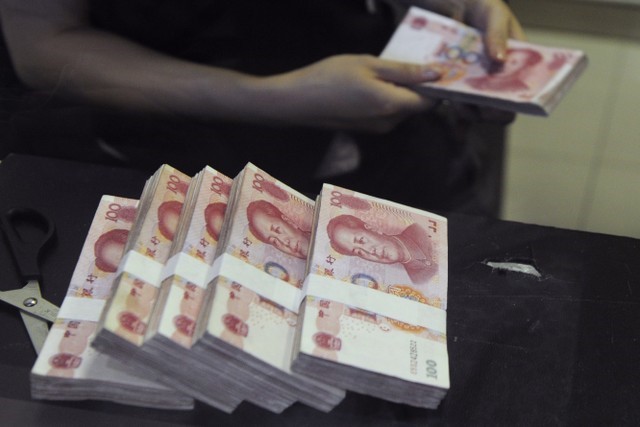 © Reuters. An employee counts Chinese 100 yuan banknotes at a branch of China Merchants Bank in Hefei