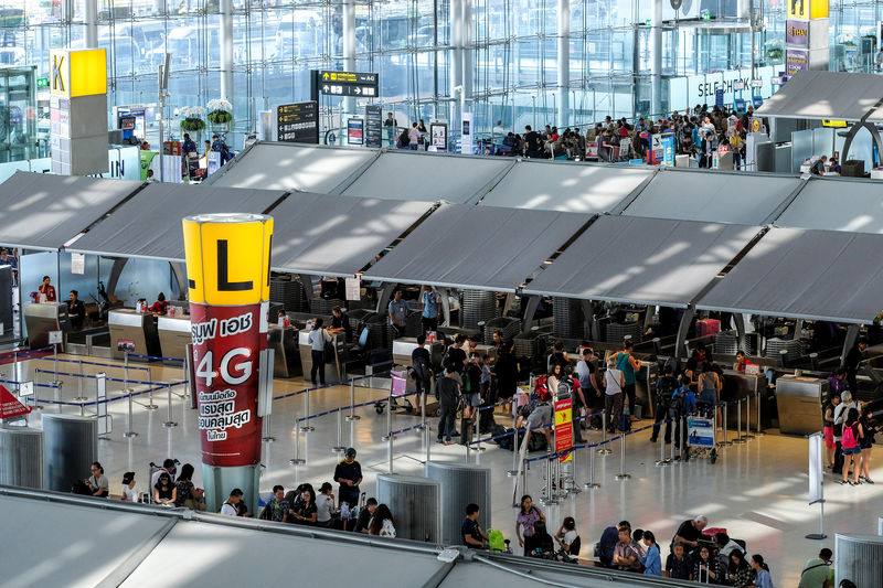 © Reuters. Tourists queue to check in at Suvarnabhumi International Airport in Bangkok