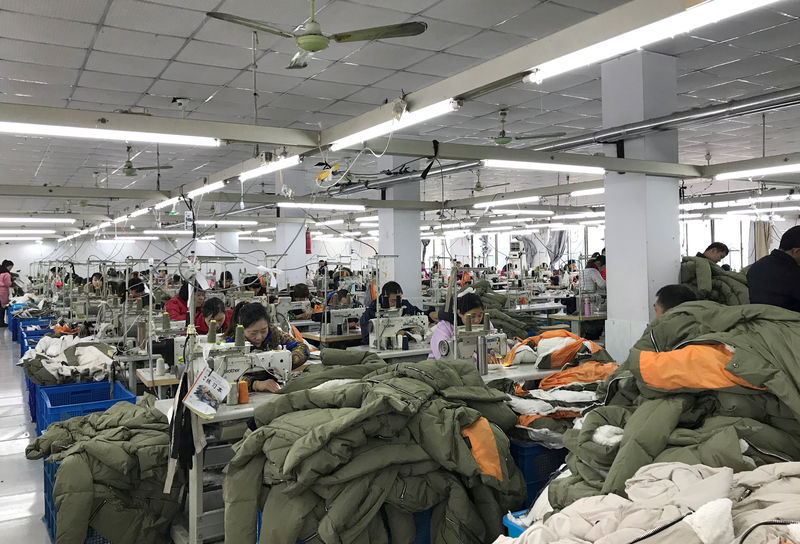 © Reuters. FILE PHOTO: Workers make Orolay jackets at the company's factory complex in Jiaxing, Zhejiang