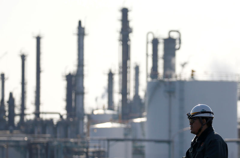 © Reuters. FILE PHOTO: A worker walks near a factory at the Keihin industrial zone in Kawasaki