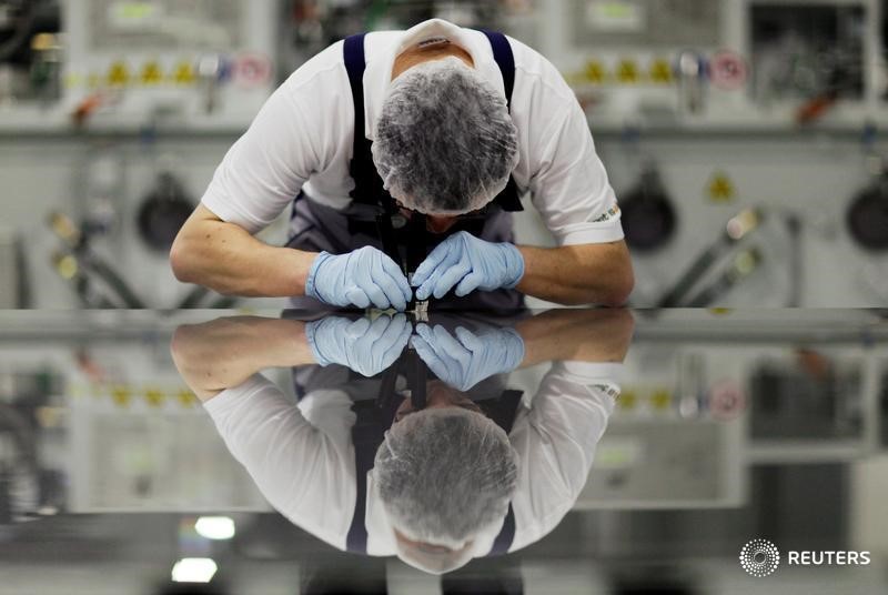 © Reuters. A worker of Signet Solar checks a photovoltaic module in a plant in Mochau near Dresden