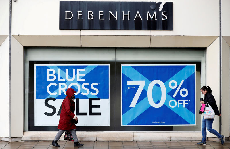 © Reuters. FILE PHOTO: People walk past a Debenhams store in Stockport