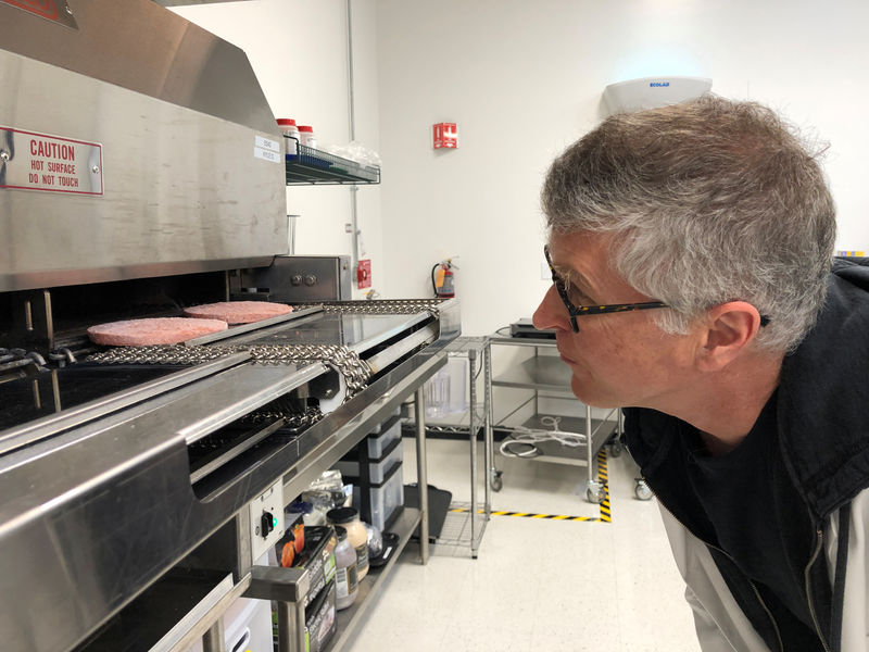 © Reuters. Impossible Foods Chief Executive Pat Brown poses in front of a flame broiler cooking its plant-based patties at a facility in Redwood City