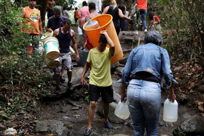 © Reuters. En medio de apagones, los venezolanos se abastecen con más velas y tanques de agua