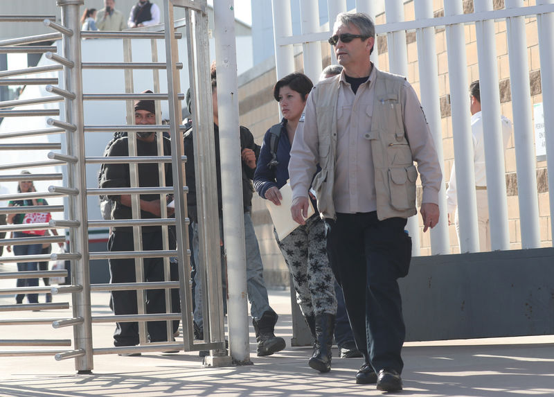 © Reuters. FILE PHOTO: Central American asylum seekers are escorted out of the Chaparral border crossing gate after being sent back to Mexico by the U.S. in Tijuana, Mexico