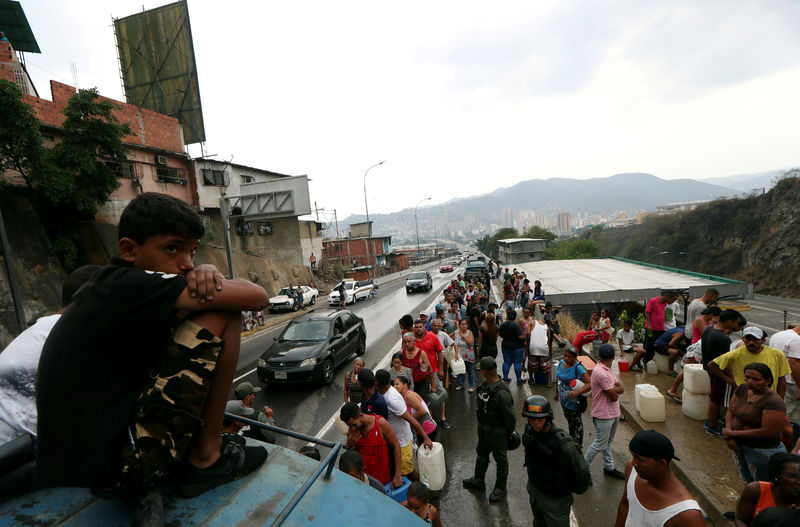 © Reuters. Gente junta agua en Caracas.