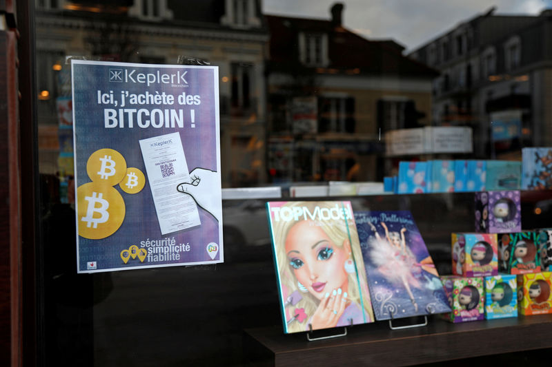 © Reuters. FILE PHOTO: A placard of French startup Keplerk, for clients to purhcase bitcoins, is seen inside a tobacco shop at Rueil-Malmaison