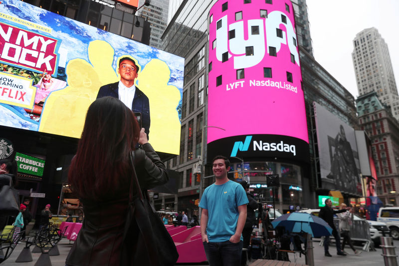 © Reuters. Brian Friedenberg, an intern for Lyft, has his picture taken in front of signage for Lyft as it is displayed at the NASDAQ MarketSite in Times Square in celebration of its initial public offering (IPO) on the NASDAQ Stock Market in New York