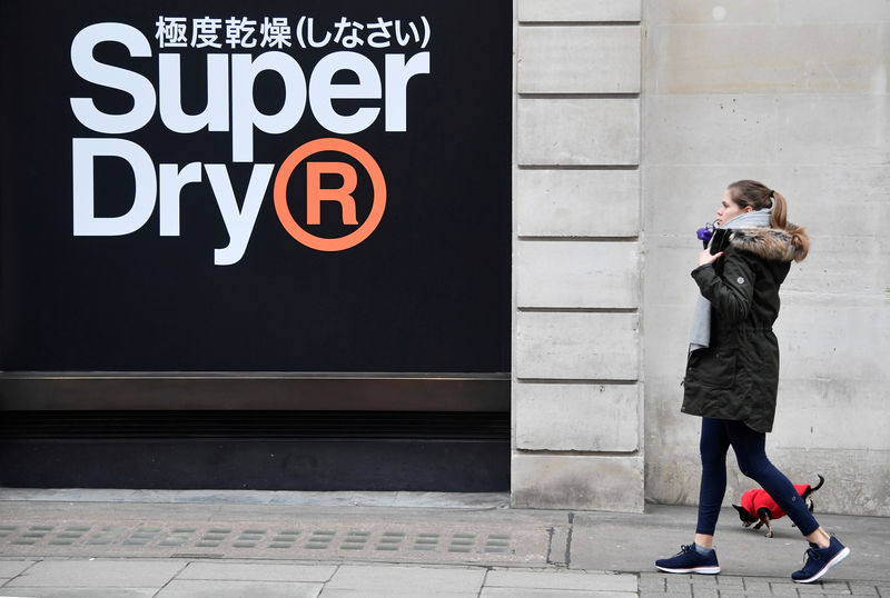 © Reuters. FILE PHOTO: A woman walks past a window display at a Superdry store in London