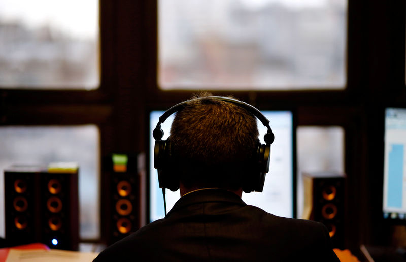 © Reuters. Homem ouvindo música em fones de ouvido enquanto mexe no computador