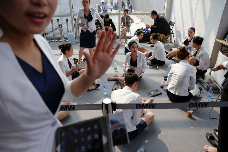 © Reuters. Hostesses rest during the Auto China 2016 auto show in Beijing