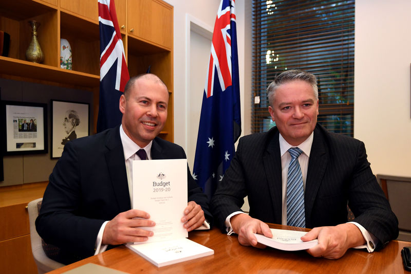 © Reuters. Treasurer Josh Frydenberg poses for a photograph with Minister for Finance Mathias Cormann with the 2019 Budget papers ahead of Budget 2019 at Parliament House in Canberra