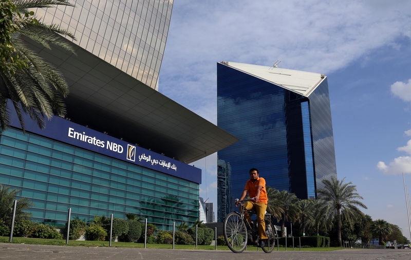 © Reuters. A man rides a bicycle past Emirates NBD head office in Dubai