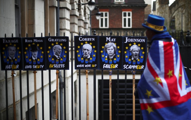 © Reuters. Manifestante anti-Brexit passa por cartaz de protesto em Londres