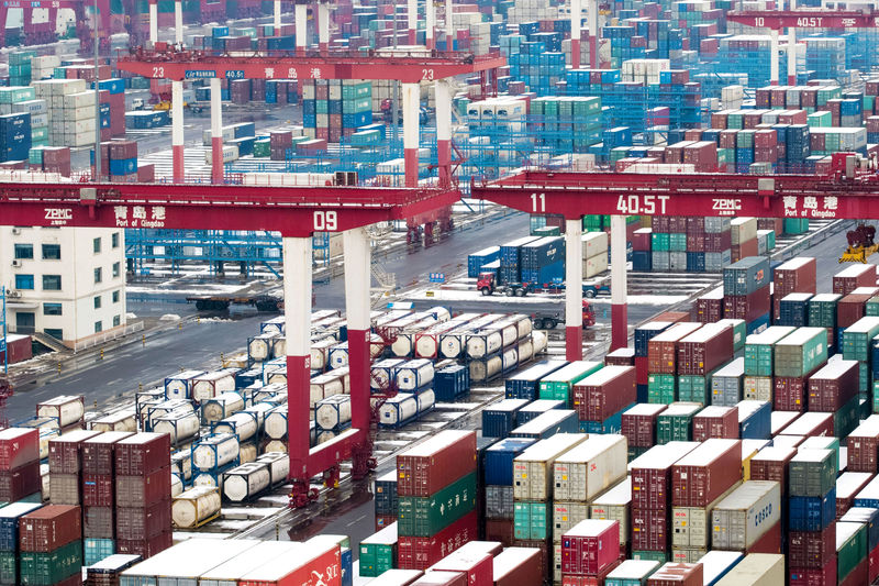 © Reuters. FILE PHOTO:  Containers and trucks are seen following a snowfall at the port of Qingdao