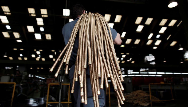 © Reuters. FILE PHOTO: An employee carries copper hoses at the SPTF metallurgical company in Sao Paulo