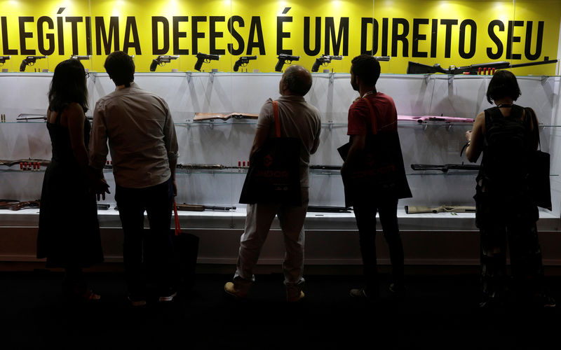 © Reuters. Pessoas observam armas em estande da Taurus na Laad, no Rio de Janeiro