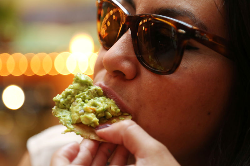 © Reuters. A woman eats guacamole in this picture illustration, in Mexico City