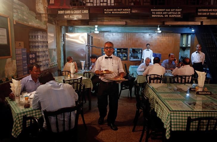 © Reuters. Waiter carries plates of food for customers at the Britannia and Co. restaurant in Mumbai