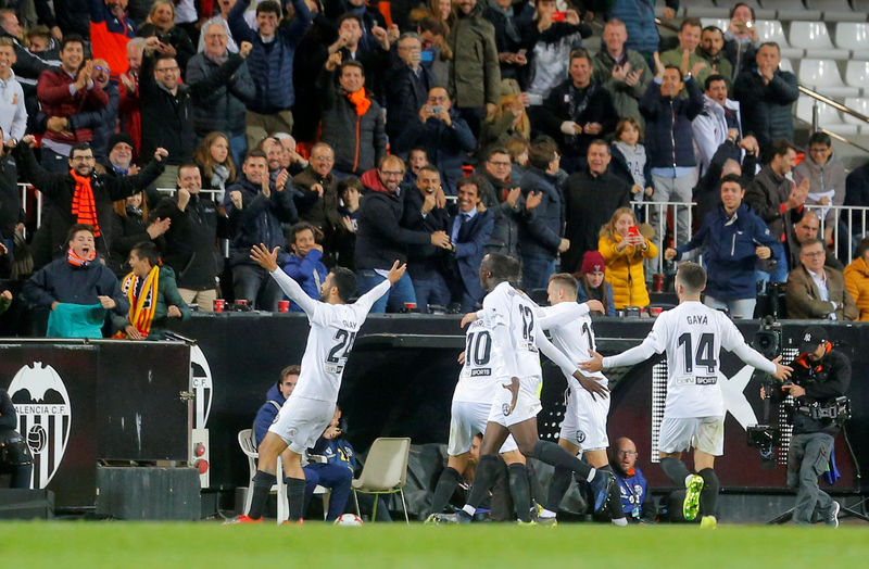 © Reuters. Ezequiel Garay celebra con sus compañeros del Valencia tras anotar el segundo gol del triunfo 2-0 sobre Real Madrid por la Liga Española de fútbol