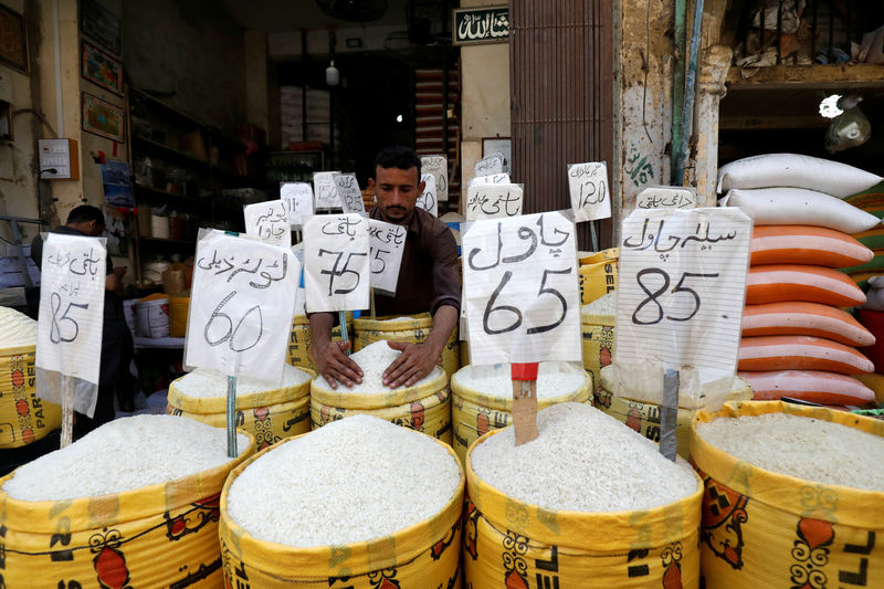 © Reuters. Vendor arranges different types of rice at his shop in a wholesale market in Karachi