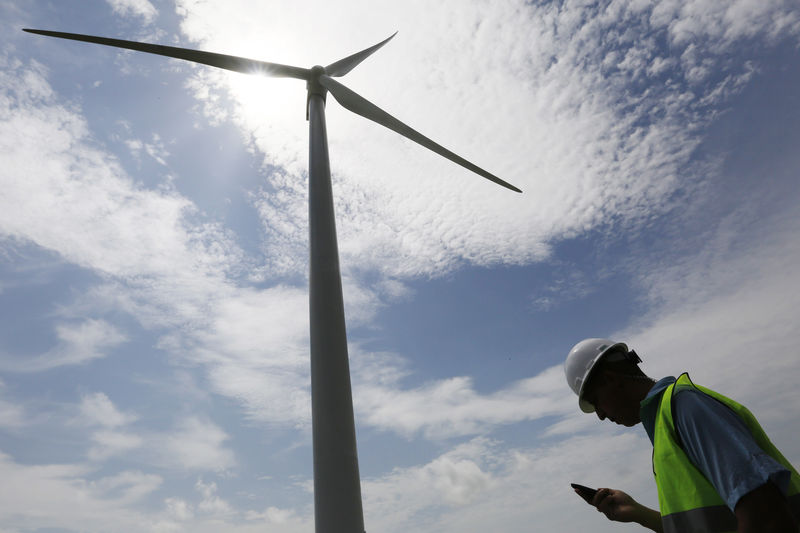 © Reuters. Funcionário confere celular próximo a turbina eólica em Penonomé, Panamá