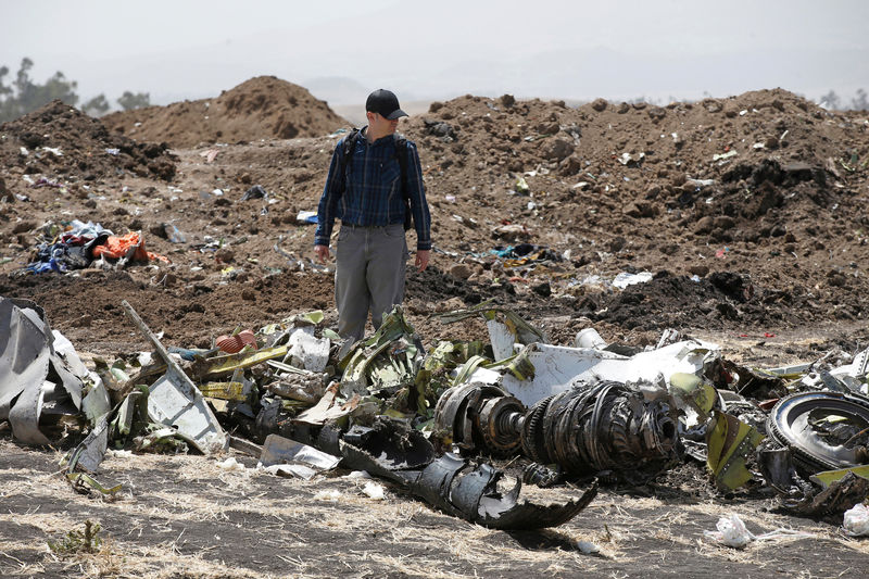 © Reuters. FILE PHOTO - American civil aviation and Boeing investigators search through the debris at the scene of the Ethiopian Airlines Flight ET 302 plane crash, near the town of Bishoftu, southeast of Addis Ababa